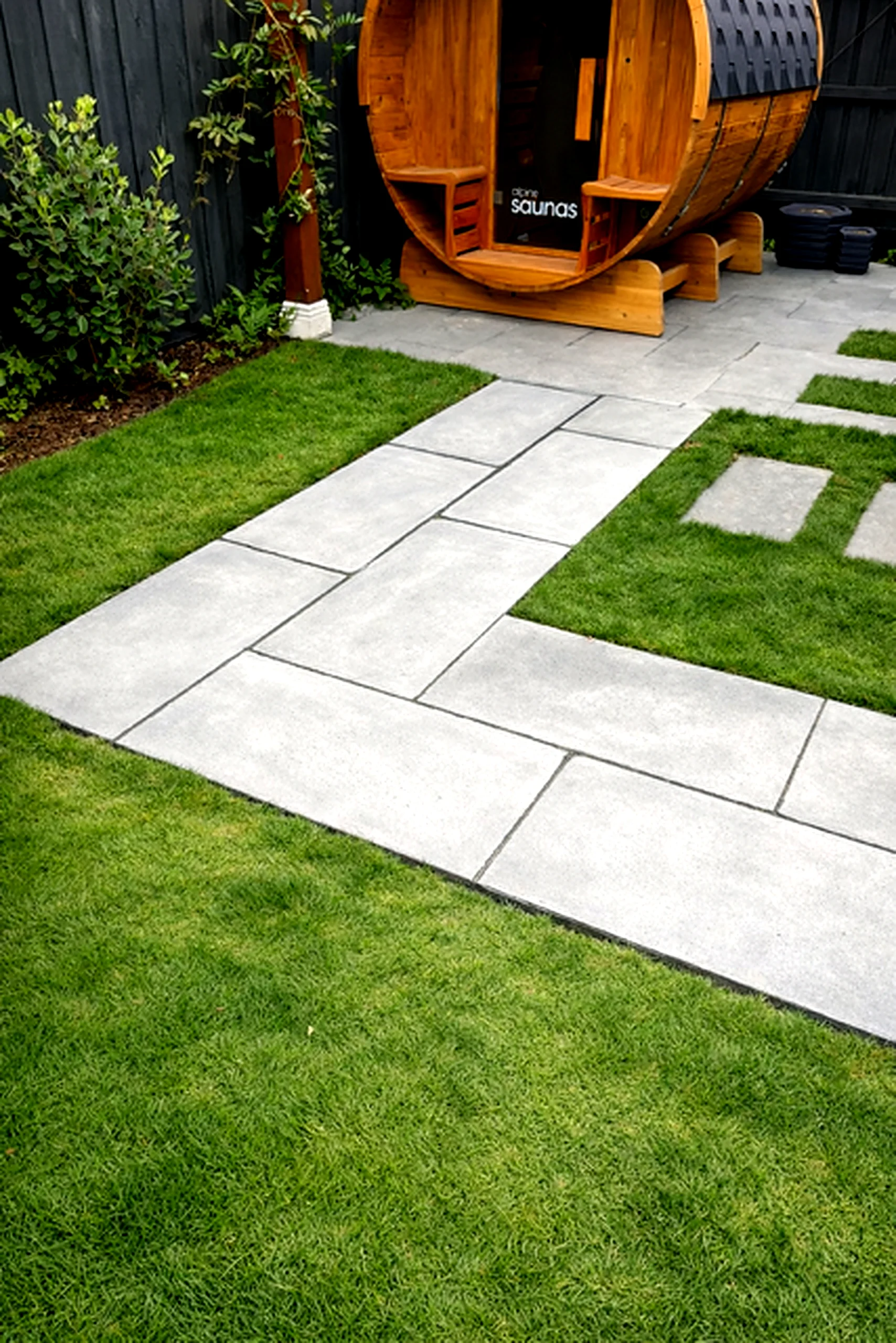 Bluestone paving pathway leading to barrel sauna set in open turf, Yarraville
