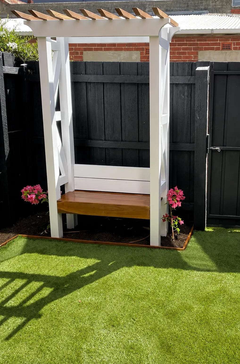 Freestanding timber arbour bench seat with bougainvillea and synthetic turf, Footscray Melbourne